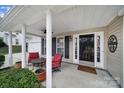 Inviting front porch with red chairs and a table, creating a cozy atmosphere at 3812 Leela Palace Way, Fort Mill, SC 29708