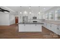 Modern kitchen with white shaker cabinets, stainless steel appliances, and an island at 5605 Miami Ln, Concord, NC 28025