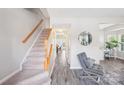 Bright entryway with stairs, wood railing, and a view into the living room at 6033 Creft Cir, Indian Trail, NC 28079