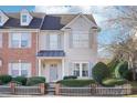 Two-story townhome with brick and siding exterior, featuring a gray door and a white picket fence at 6033 Creft Cir, Indian Trail, NC 28079