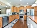 Well-equipped kitchen with stainless steel appliances, granite countertops, wood cabinets, and hardwood flooring at 8024 Carolina Lakes Way, Fort Mill, SC 29707