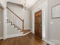 Bright entryway with hardwood floors, staircase, and a view into the living area at 813 Garbow Ct, Charlotte, NC 28270