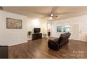 Bright living room features hardwood-style floors, a ceiling fan, and a decorative tree at 9009 Powder Works Dr, Huntersville, NC 28078