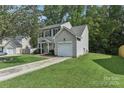 Two-story house with gray siding, a white door, and a two-car garage at 9022 Belle Bragg Way, Charlotte, NC 28214