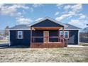 Charming house with a wooden front porch and dark-colored siding at 110 Hubbard St, Belmont, NC 28012