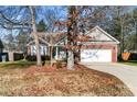 Brick ranch house with a two-car garage and mature trees at 11104 Fox Cove Dr, Charlotte, NC 28273