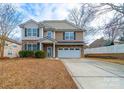 Attractive two-story home featuring stone accents, blue shutters, a two-car garage and meticulous landscaping at 1120 Spicewood Pines Rd, Fort Mill, SC 29708