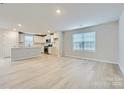 Open-concept living room with modern flooring, neutral paint, lots of natural light, and a view of the kitchen at 1175 Blackburn Cir, Edgemoor, SC 29712