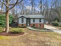 Ranch house with a landscaped yard and driveway, nestled among trees at 204 Swamp Fox Dr, Fort Mill, SC 29715