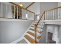 Open staircase with wooden railing, overlooking living area with fireplace at 204 Swamp Fox Dr, Fort Mill, SC 29715