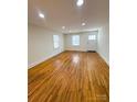 Bright, sunlit living room with wood floors and a door leading to the outside at 238 Coxe Ave, Charlotte, NC 28208