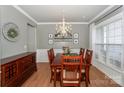 Formal dining room with wainscoting, a modern chandelier, and a large window for natural light at 265 Sutro Forest Nw Dr, Concord, NC 28027