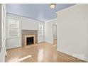 Bright living room featuring hardwood floors, a decorative fireplace, and freshly painted white walls at 3724 Commonwealth Ave, Charlotte, NC 28205