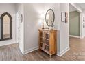 Bright entryway with wood cabinet, mirror, and laminate wood flooring at 5066 Summer Surprise Ln, Charlotte, NC 28215