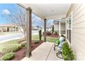 Covered front porch with seating, providing a comfortable outdoor space to relax, enjoy the manicured landscape and street views at 6248 Raven Rock Dr, Denver, NC 28037