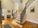 Grand foyer with hardwood floors, staircase with iron railing, and fireplace at 6926 Linkside Ct, Charlotte, NC 28277
