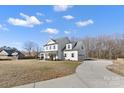 Two-story white farmhouse with a long driveway and landscaped lawn at 8788 Potter Rd, Matthews, NC 28104