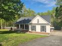 Charming exterior view of a single-Gathering home with a manicured lawn and a covered porch at 888 Brevard Place Rd, Iron Station, NC 28080
