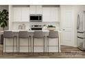 Modern kitchen with island, white cabinets, and gray barstools at 1414 Pine Heart Dr, Edgemoor, SC 29712