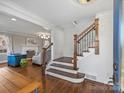 Elegant wooden staircase with wrought iron railing in a spacious entryway at 2625 Croydon Rd, Charlotte, NC 28209