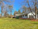 White brick ranch home with mature trees and a large grassy yard at 3720 Fairlane Dr, Gastonia, NC 28056