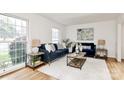 Bright living room featuring hardwood floors, stylish furnishings, and large windows at 3828 Chandworth Rd, Charlotte, NC 28210