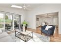 Bright living room featuring a ceiling fan, skylight, and access to the outdoor patio at 3828 Chandworth Rd, Charlotte, NC 28210