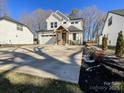 Two-story home with white siding, a brown door, and a long driveway at 604 N Providence St, Waxhaw, NC 28173