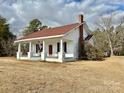 Side view of a charming white house with a red roof at 6963 Kershaw Camden Hwy, Kershaw, SC 29067