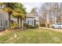 Townhouse showcasing a well-maintained front yard with palm trees and stone accents at 7513 Mariner Cove Dr, Cornelius, NC 28031