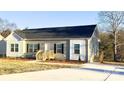 Charming home featuring gray siding, black shutters, complemented by a welcoming wooden porch and long drive way at 823 Wellwood Ave, Statesville, NC 28677