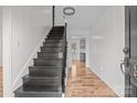 Entryway with hardwood floors and a dark staircase leading upstairs at 841 Deerfield Dr, Mount Holly, NC 28120