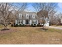 Gray sided two-story house with a two-car garage and mature trees at 841 Deerfield Dr, Mount Holly, NC 28120