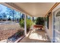 Front porch with a wooden swing and brick flooring at 8622 Lower Rocky River Rd, Concord, NC 28025