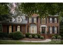 Brick home with black shutters, landscaping, and a walkway, nighttime view at 8804 Ferngrove Ct, Waxhaw, NC 28173