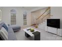 Living room with gray sectional sofa, coffee table, and stairs at 8804 Ferngrove Ct, Waxhaw, NC 28173