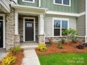 Inviting townhouse front door with stone accents, manicured landscaping, and a welcoming entryway at 10119 Mamillion Dr, Huntersville, NC 28078