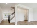 Bright living room with wood-look floors, staircase with black railing, and open floorplan layout at 10119 Mamillion Dr, Huntersville, NC 28078