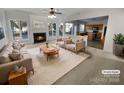 Spacious living room featuring a fireplace and kitchen view at 18414 Victoria Bay Dr, Cornelius, NC 28031