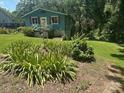 Quaint cottage-style home with well-manicured lawn and vibrant flowerbeds in a peaceful, wooded setting at 198 Clouse Ln, Taylorsville, NC 28681
