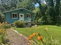 Charming cottage-style home with a well-maintained lawn and beautiful flowerbeds in a serene, wooded setting at 198 Clouse Ln, Taylorsville, NC 28681