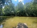 Scenic view of a calm pond surrounded by lush greenery, reflecting the clear blue sky at 198 Clouse Ln, Taylorsville, NC 28681
