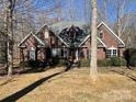 Two-story brick home with a spacious front yard and wooded backdrop at 2113 Sweet Clover Way, Denver, NC 28037