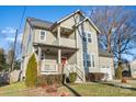 Two-story craftsman style home with red door, attached garage, and manicured lawn at 2408 Rozzelles Ferry Rd, Charlotte, NC 28208