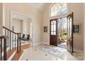 Grand foyer with tiled flooring, staircase, and arched doorway leading to a living area at 2907 Cutter Ct, Waxhaw, NC 28173