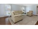 Comfortable living room with hardwood floors, neutral paint, and a large window for natural light at 3041 Valencia Ter, Charlotte, NC 28211