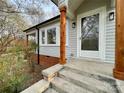 View of the front porch with wooden support beams and concrete steps, showcasing the entrance to the home at 400 E 27Th St, Kannapolis, NC 28083