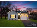 Newly built home with gray siding, a two-car garage, and a well-manicured lawn at 6325 Rockwell W Blvd, Charlotte, NC 28269