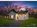 Newly built home with gray siding, a two-car garage, and a well-manicured lawn at 6325 Rockwell W Blvd, Charlotte, NC 28269