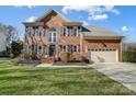 Two-story brick home with a landscaped lawn and attached garage at 9236 Silver Pine Dr, Charlotte, NC 28277